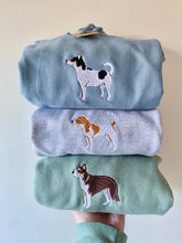 Load image into Gallery viewer, Stack of three sweatshirts with full colour embroidered dog breeds, each in different colors. top tri colour jack Russell on blue sweatshirt, middle tan and white jack russell dog on grey, bottom tri colour brown collie on dusty green sweatshirt.