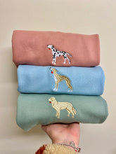 Load image into Gallery viewer, Full colour embroidered sweatshirts displayed in a stack. dalmatian with rose in its mouth on a dusty pink sweatshirt, a beige sighthound on a sky blue sweatshirt , a beige golden retriever on a dusty green sweatshit.