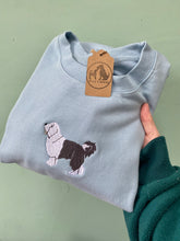 Load image into Gallery viewer, A sky blue sweatshirt with a full colour old english sheepdog embrpidered in the centre.
